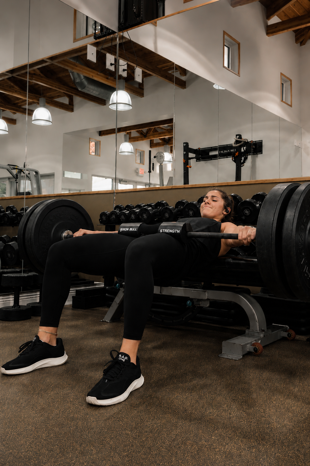 Athlete performing a loaded barbell hip thrust in a strength and conditioning facility